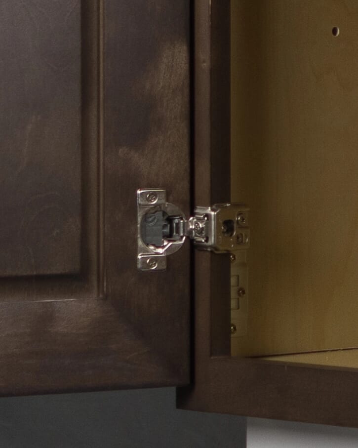 Close-up view of Tuscany cabinet hinge hardware installed on interior cabinet panel
